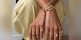 Hands resting on a knee, wearing Oomiay rings