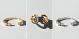 Gold and silver Oomiay rings stacked together on a cherry