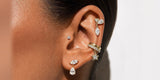 An ear styled with Oomiay ear cuffs and drop earrings, no new piercings