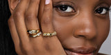 A woman wearing Oomiay gold rings, including the Crush heart ring