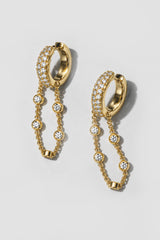 Gold Eclipse Earrings. Pavé huggie of mixed-size crystals with a draped bezel crystal chain
