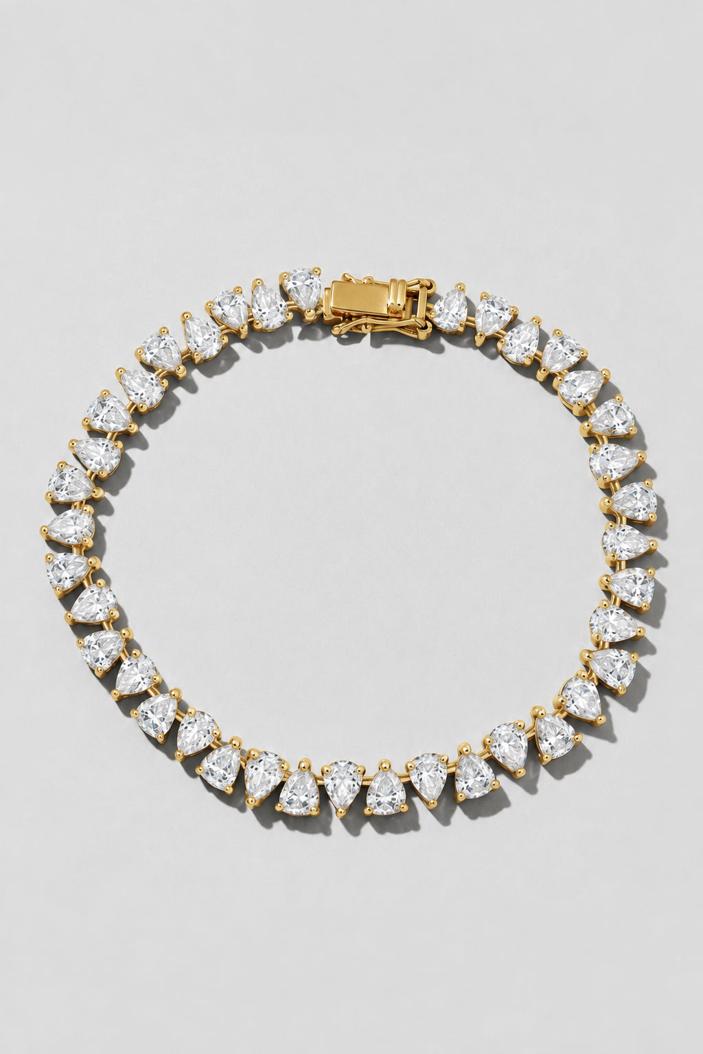 Gold Reverse Pear Cut Tennis Bracelet. Hand-linked tennis bracelet of 5x7mm reverse pear cut white crystals