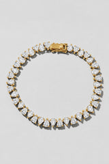 Gold Reverse Pear Cut Tennis Bracelet. Hand-linked tennis bracelet of 5x7mm reverse pear cut white crystals