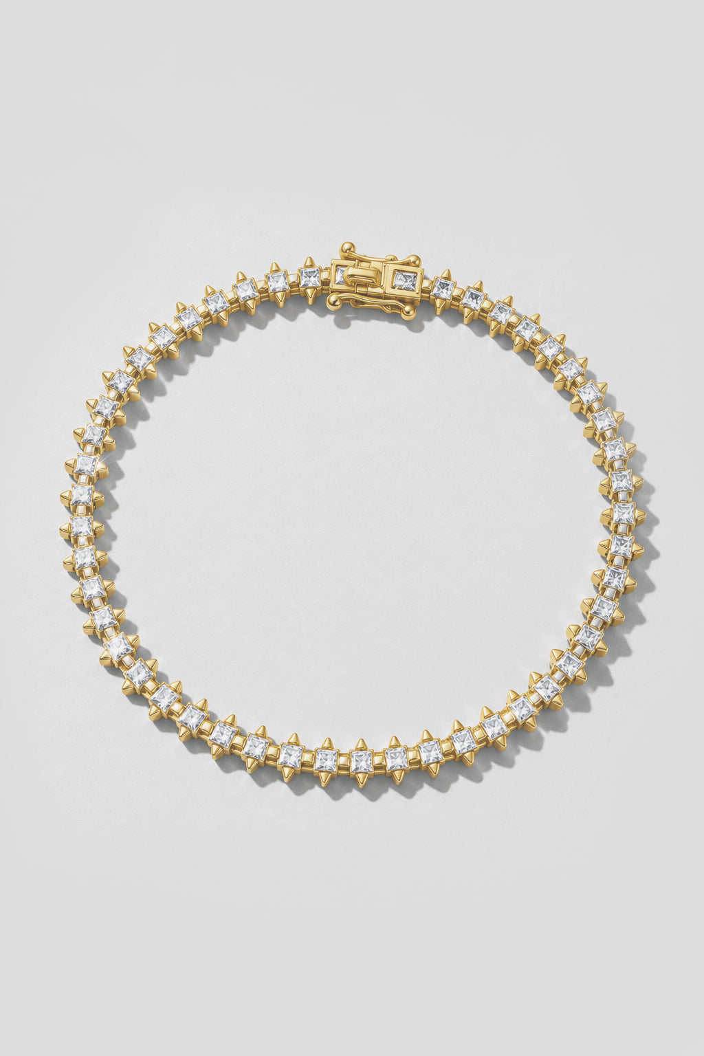 Gold Spike Tennis Bracelet. Hand-linked tennis bracelet of 2.5mm square crystals framed by spike accents