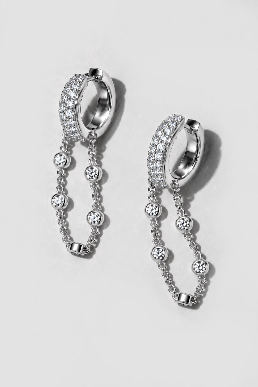 Silver Eclipse Earrings. Pavé huggie of mixed-size crystals with a draped bezel crystal chain