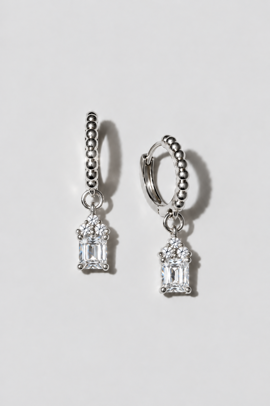 Silver Emerald Cut Huggies. Beaded huggie with a 5x7mm emerald cut white crystal charm under a three-crystal cap