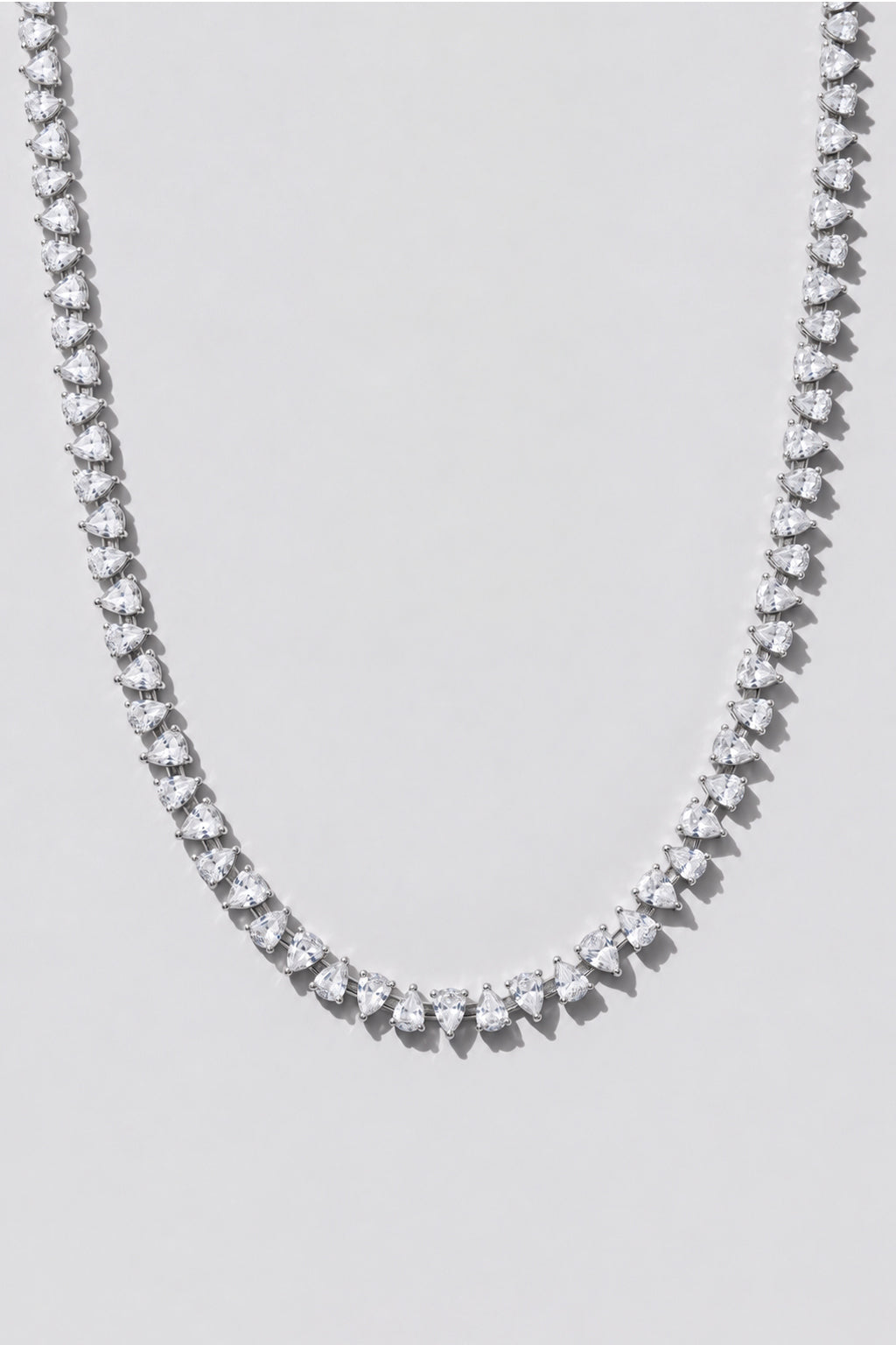Silver Reverse Pear Cut Tennis Necklace. Hand-linked tennis necklace of 5x7mm reverse pear cut white crystals, spaced with a gap between each stone so it lays flat